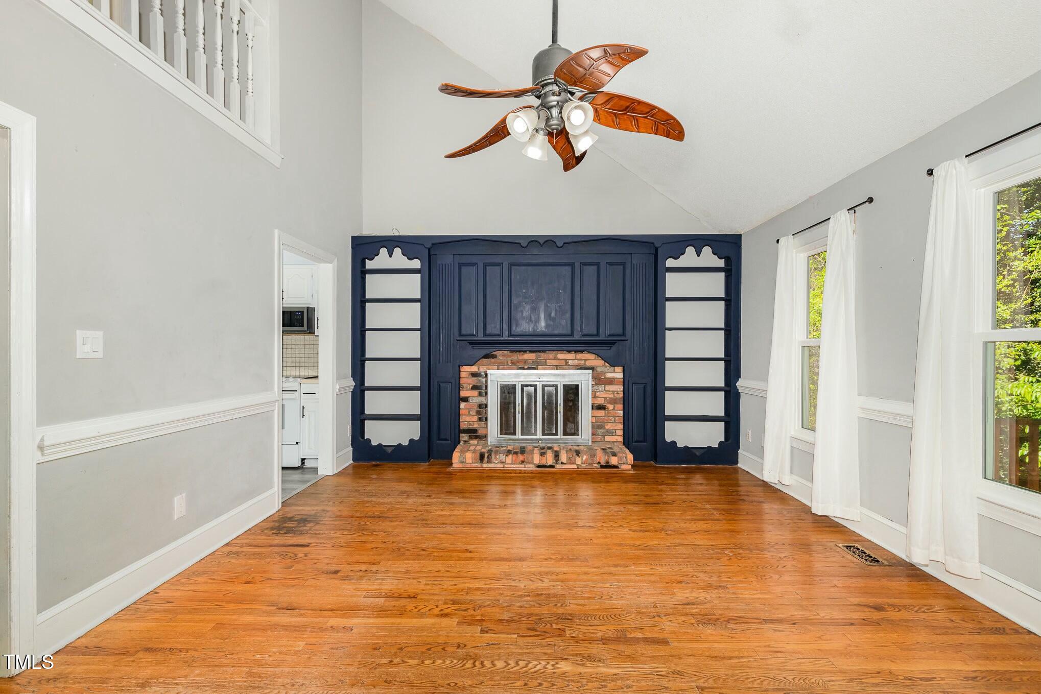 3109 East Folkestone Place Raleigh, NC 27604 - Photo 8 of 25 a large room with wooden floor and ceiling fan
