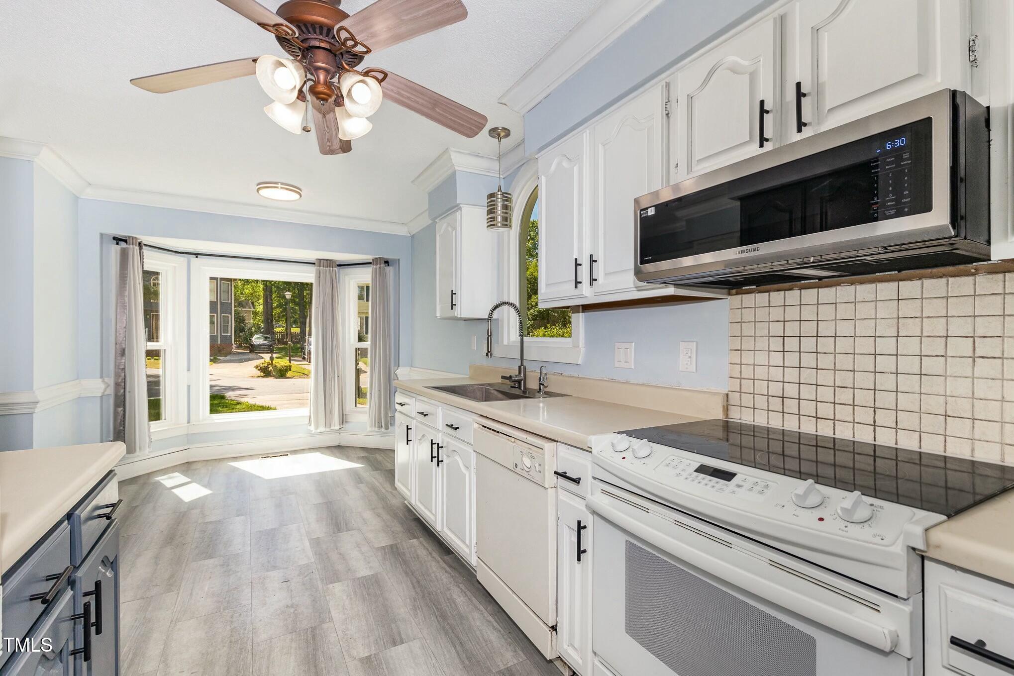 3109 East Folkestone Place Raleigh, NC 27604 - Photo 9 of 25 a kitchen with stainless steel appliances a stove microwave and cabinets
