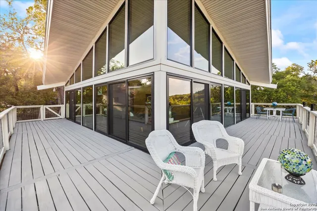 a view of a patio with couches table and chairs and wooden floor