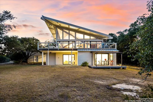 a view of a green yard with large trees