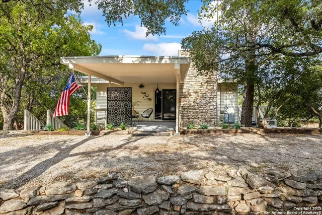 an aerial view of residential houses with outdoor space and trees