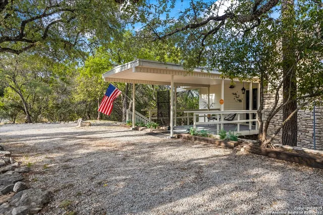 an aerial view of a house with a yard and trees all around