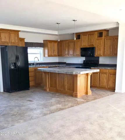 a large kitchen with stainless steel appliances granite countertop a stove top oven a sink and dishwasher