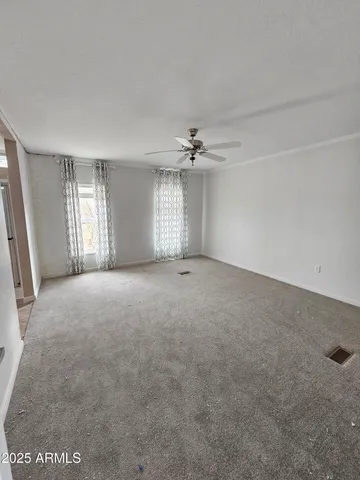 a view of a livingroom with a ceiling fan and window