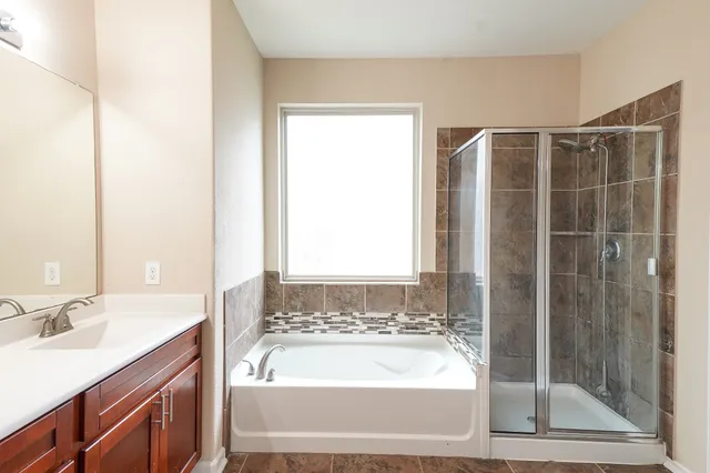 a bathroom with a tub sink and shower