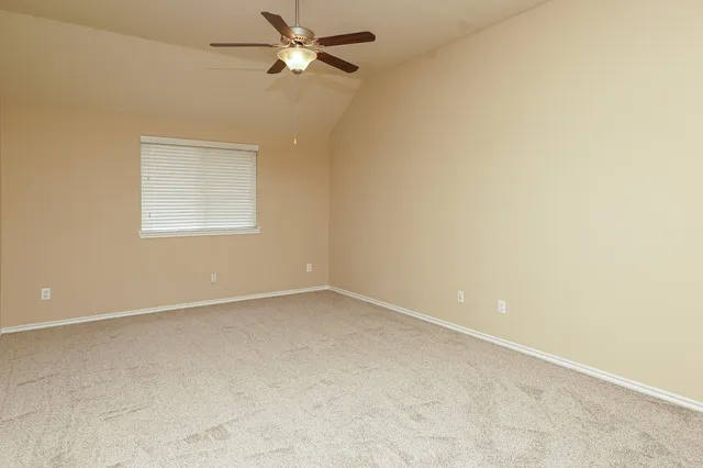 an empty room with a window and a fan