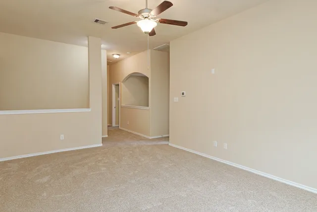 an empty room with closet and fan
