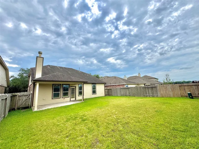 a view of a house with a yard and sitting area