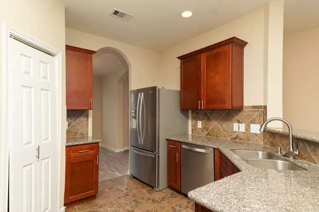 a kitchen with stainless steel appliances granite countertop a refrigerator and a sink