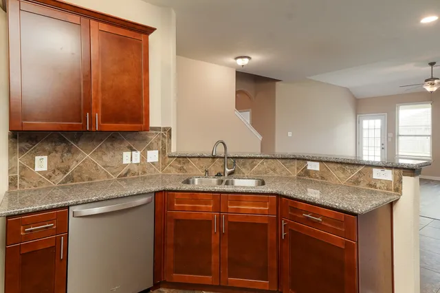 a kitchen with stainless steel appliances granite countertop a sink and cabinets