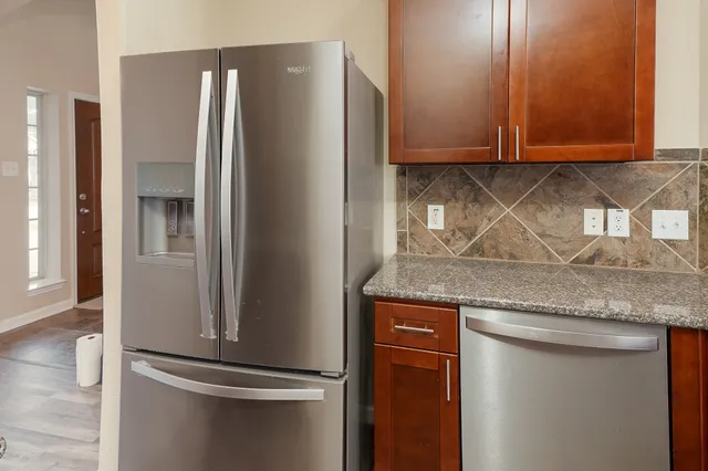 a kitchen with granite countertop stainless steel appliances and a refrigerator