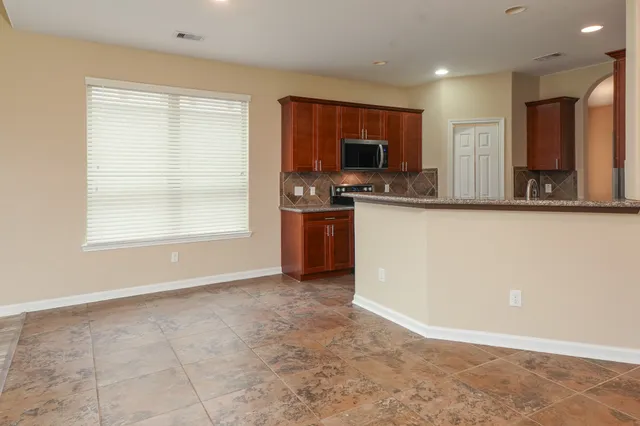 a view of a kitchen with kitchen island a sink wooden floor and a window