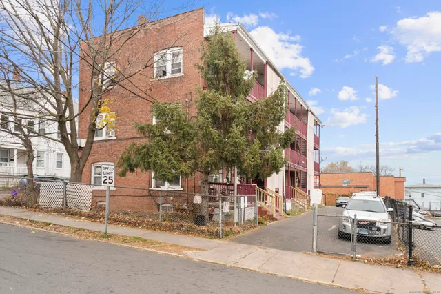 a view of a building with a bench and trees