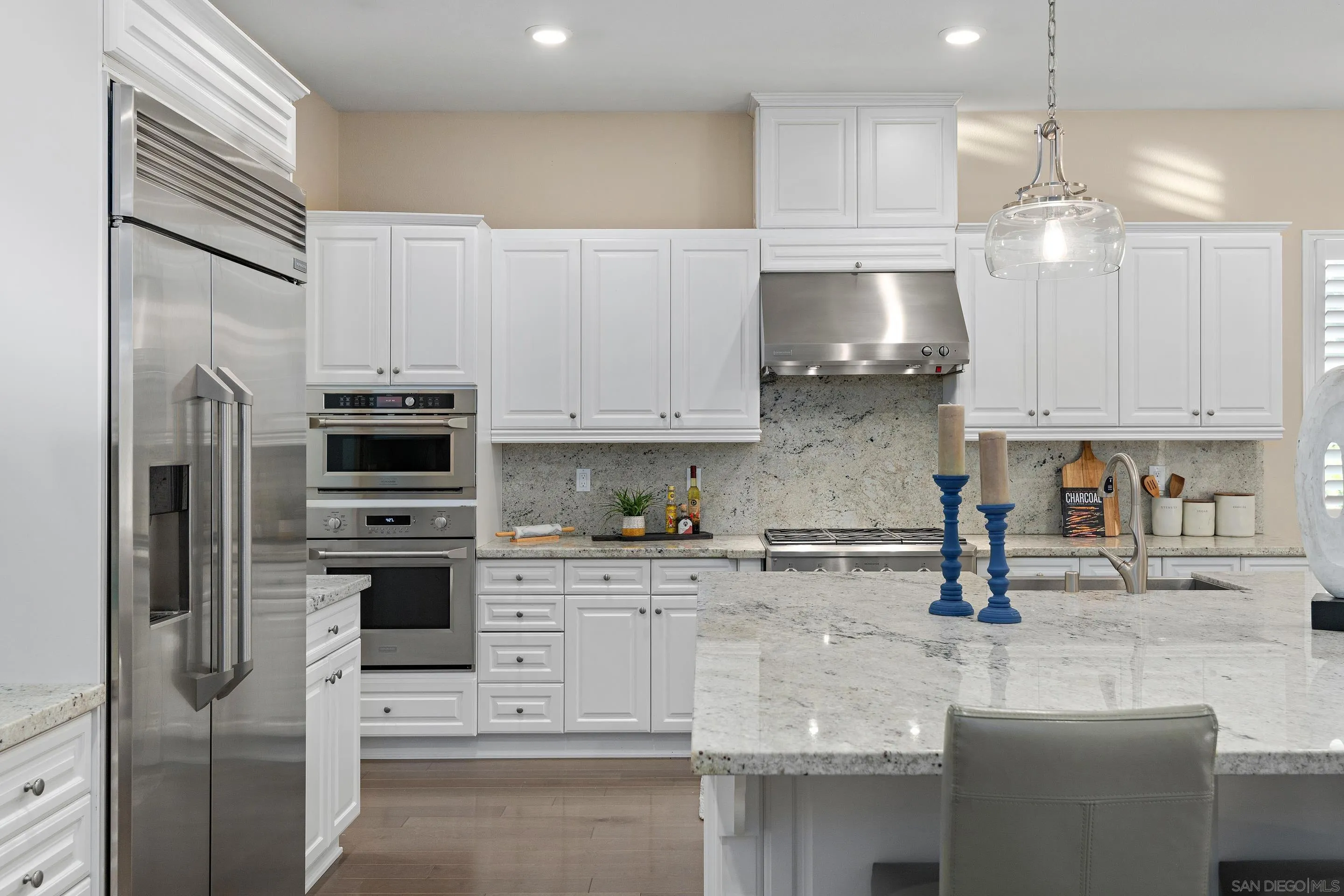5401 Reef Circle Carlsbad, CA 92008 - Photo 12 of 45 a kitchen with stainless steel appliances white cabinets a sink a stove a refrigerator and cabinets