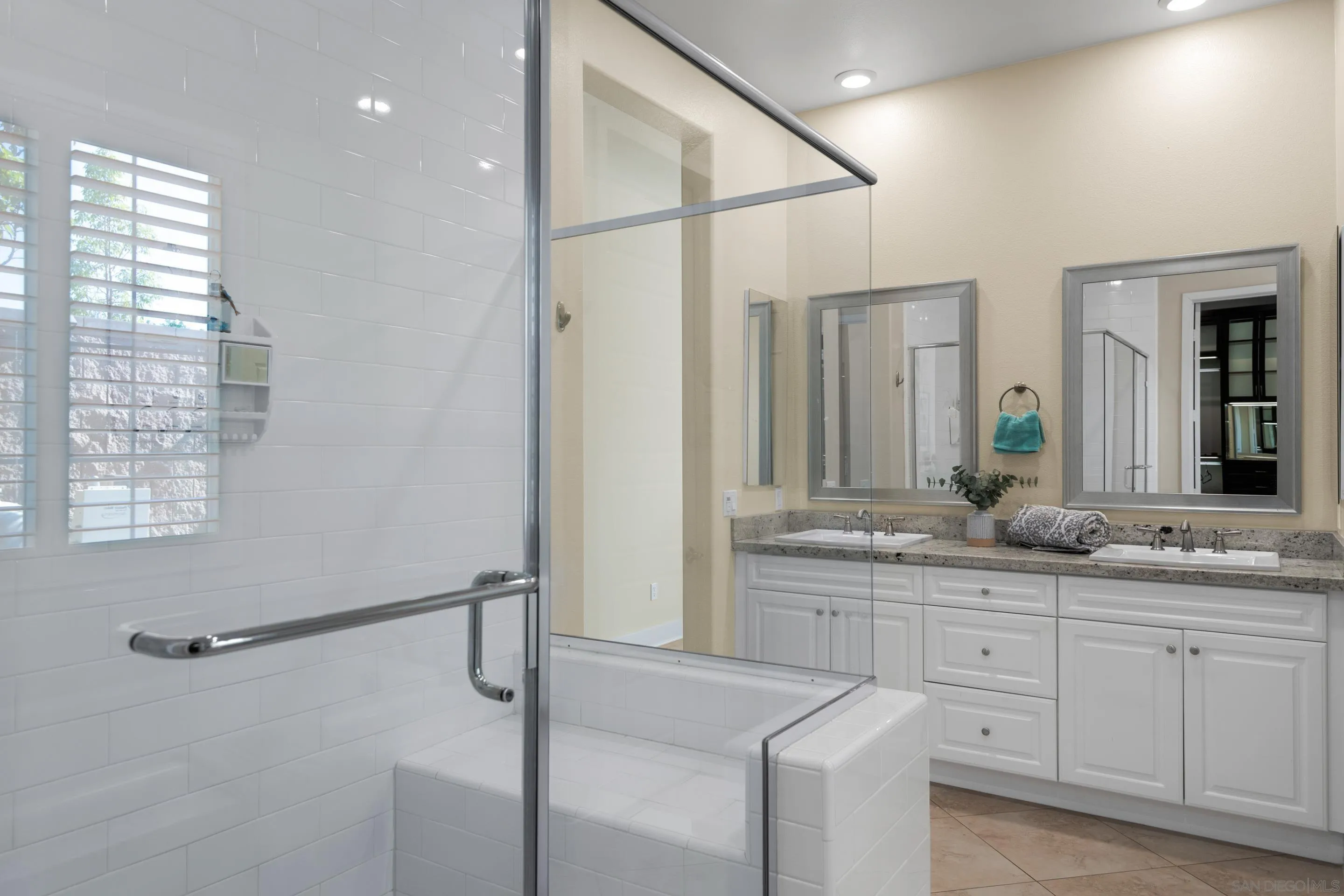 5401 Reef Circle Carlsbad, CA 92008 - Photo 27 of 45 a bathroom with a granite countertop sink a mirror and a shower