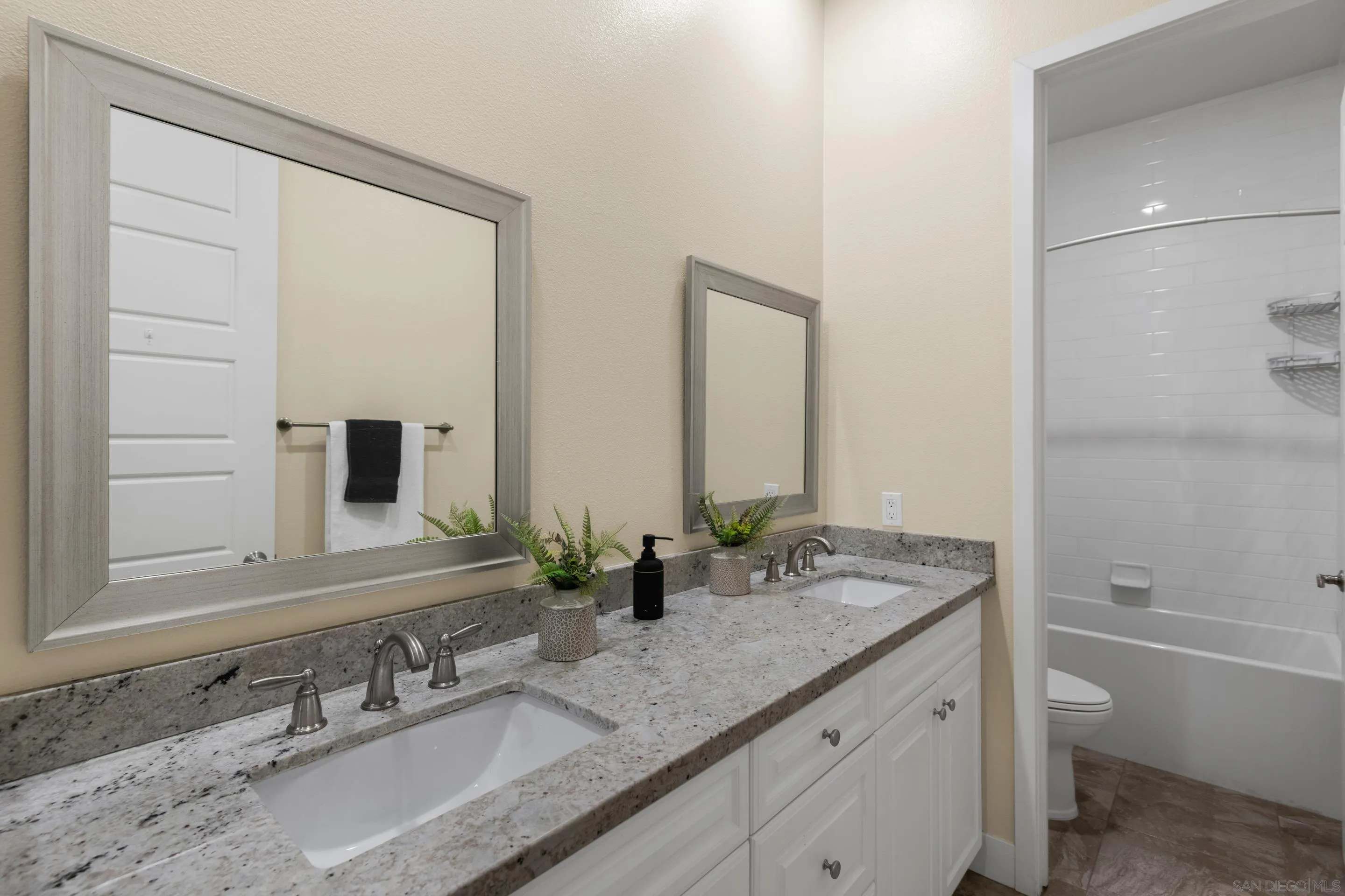 5401 Reef Circle Carlsbad, CA 92008 - Photo 31 of 45 a bathroom with a granite countertop sink and a mirror