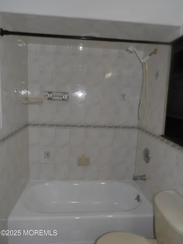 an empty room with a chandelier fan and windows