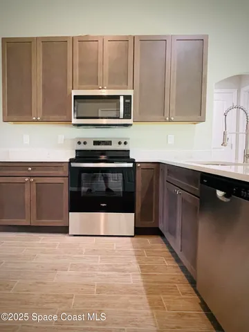a view of kitchen with furniture and refrigerator
