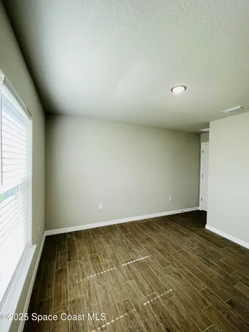 a view of an empty room with wooden floor