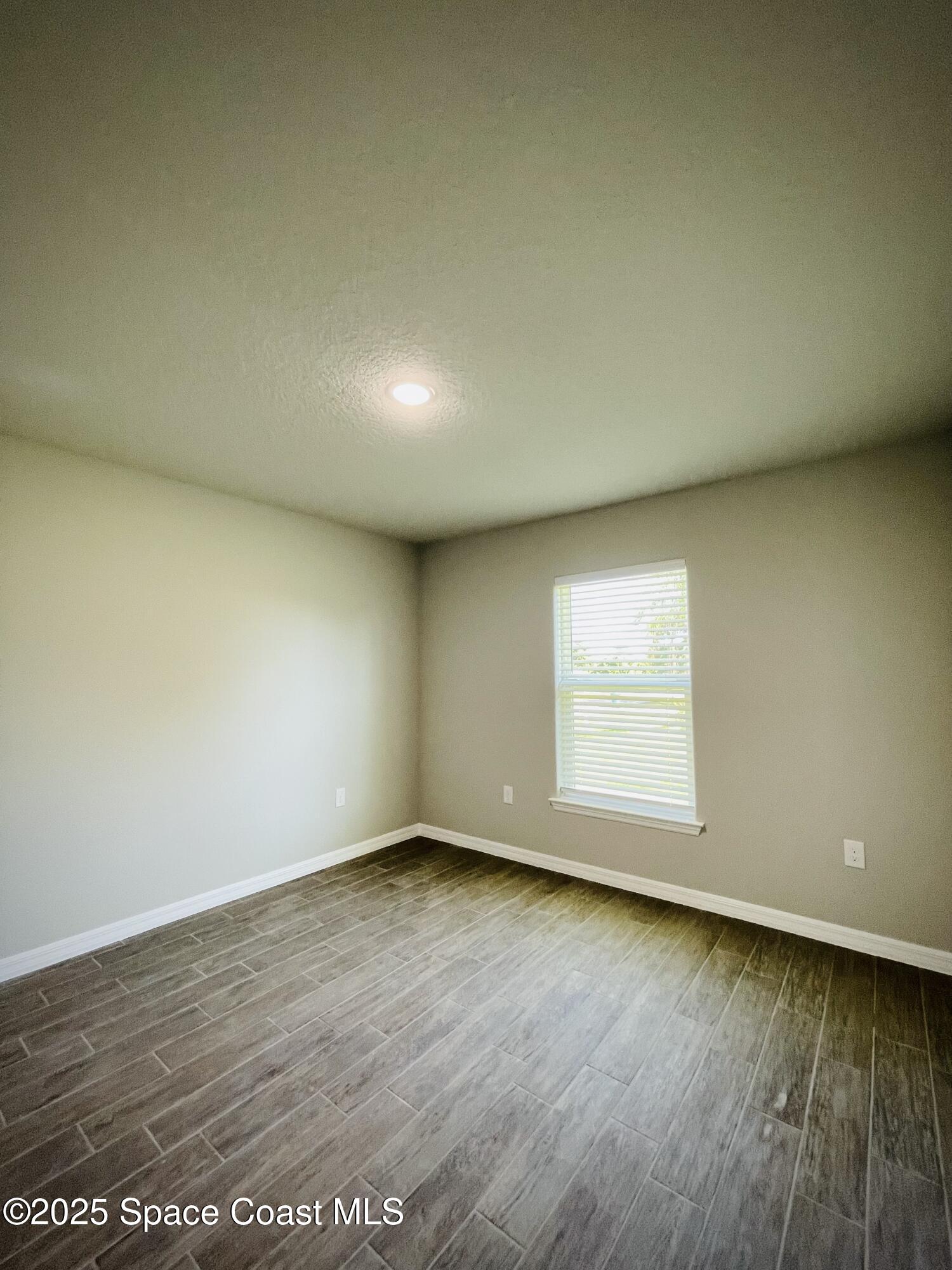334 Frederick Street Southwest Palm Bay, FL 32908 - Photo 28 of 39 an empty room with wooden floor and windows