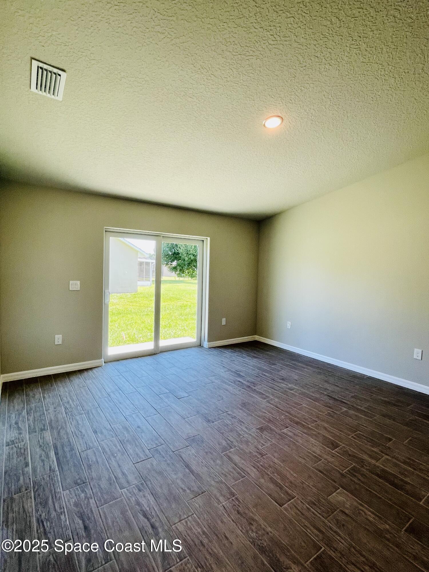 334 Frederick Street Southwest Palm Bay, FL 32908 - Photo 32 of 39 an empty room with wooden floor and a window