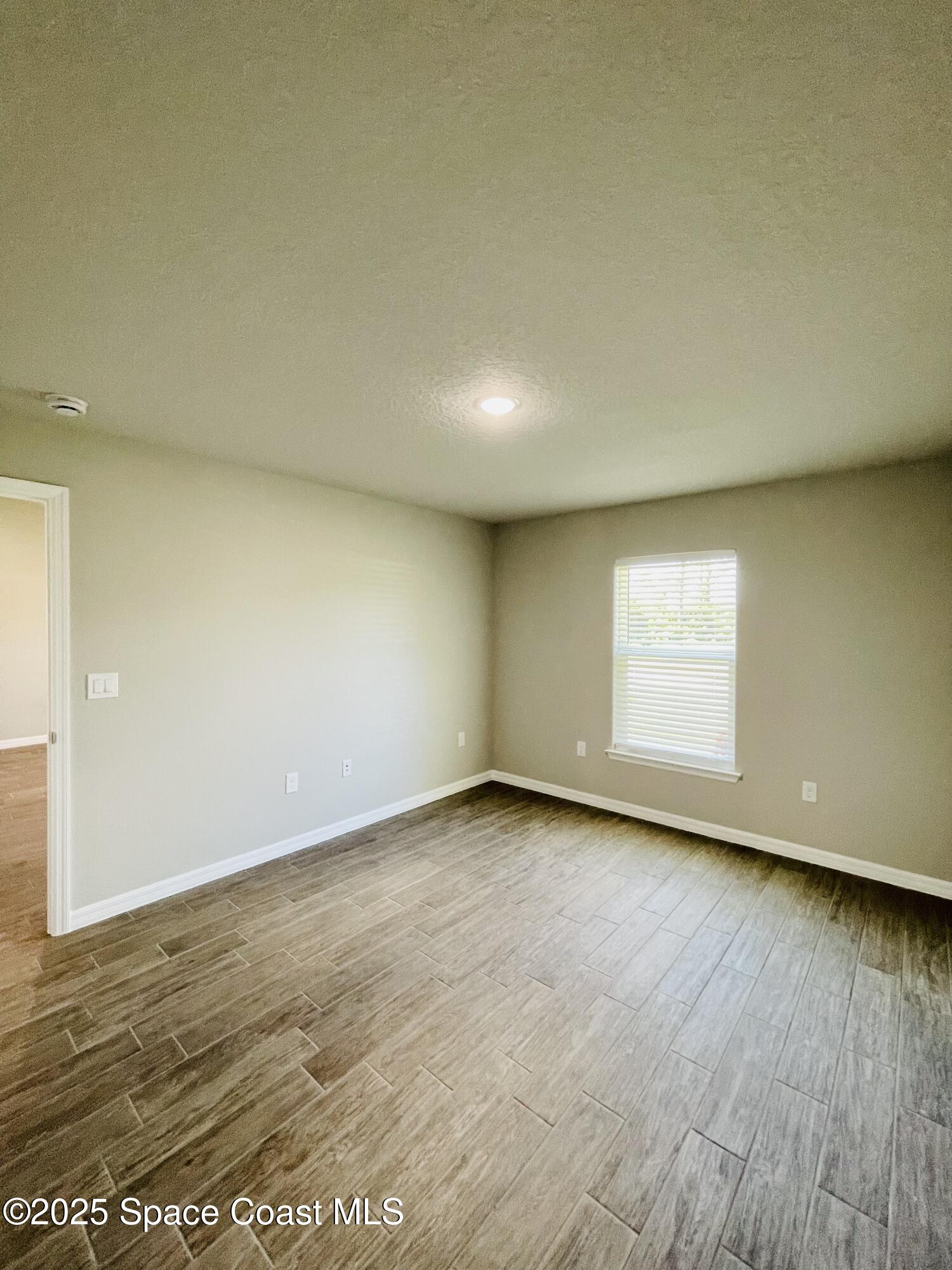 334 Frederick Street Southwest Palm Bay, FL 32908 - Photo 33 of 39 an empty room with wooden floor and windows