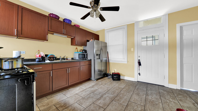 2913 West 63rd Street Chicago, IL 60629 - Photo 13 of 23 a kitchen with stainless steel appliances granite countertop a refrigerator a sink dishwasher a stove and a refrigerator with wooden cabinets
