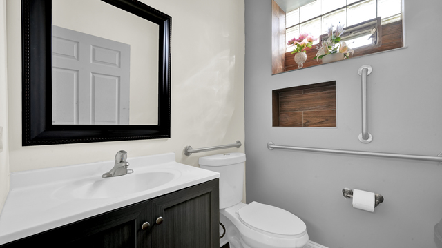 2913 West 63rd Street Chicago, IL 60629 - Photo 9 of 23 a bathroom with a toilet sink and mirror