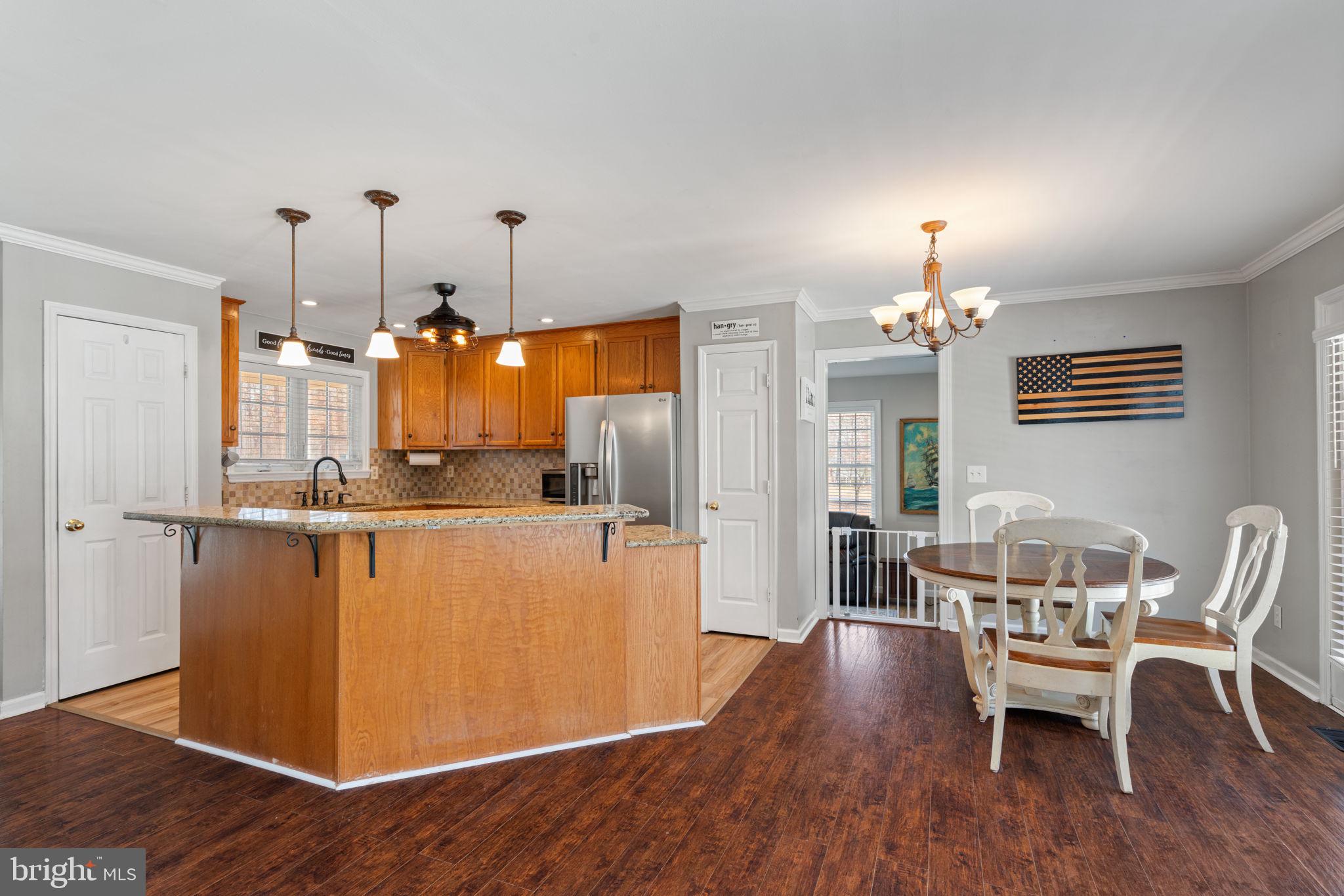 28485 Morel Way Rhoadesville, VA 22542 - Photo 13 of 42 a view of a dining room with furniture wooden floor and chandelier