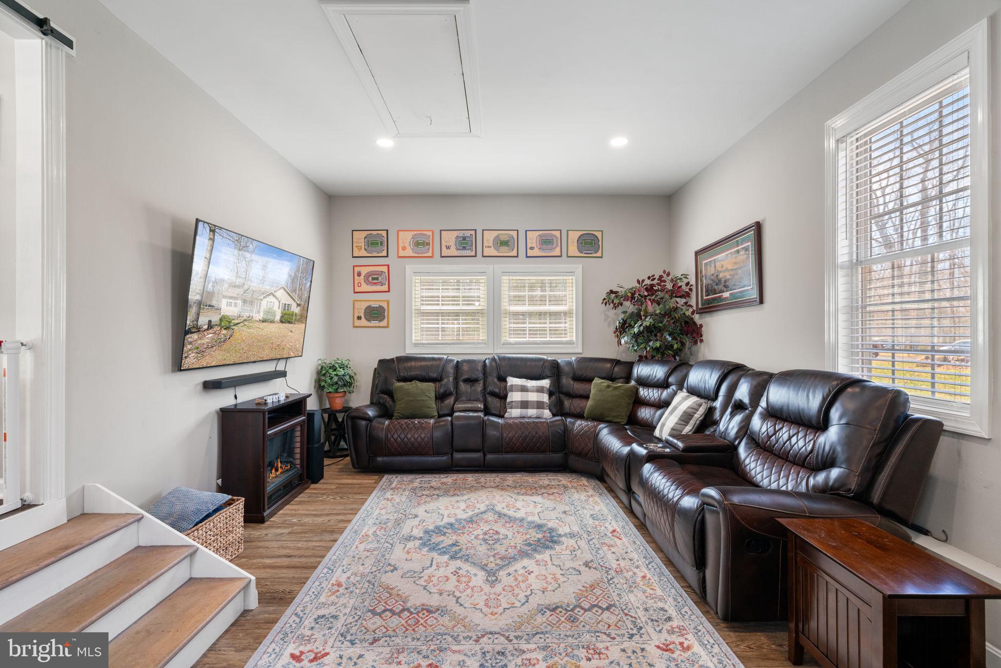 28485 Morel Way Rhoadesville, VA 22542 - Photo 16 of 42 a living room with furniture a rug and a flat screen tv