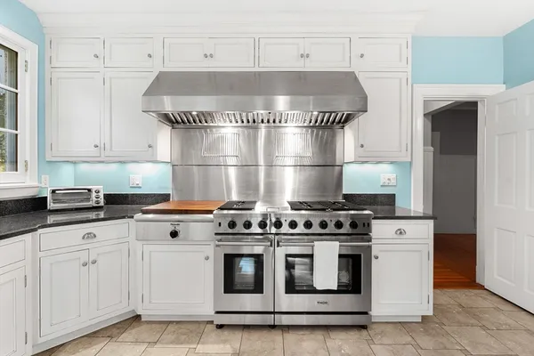 a kitchen with white cabinets and white appliances