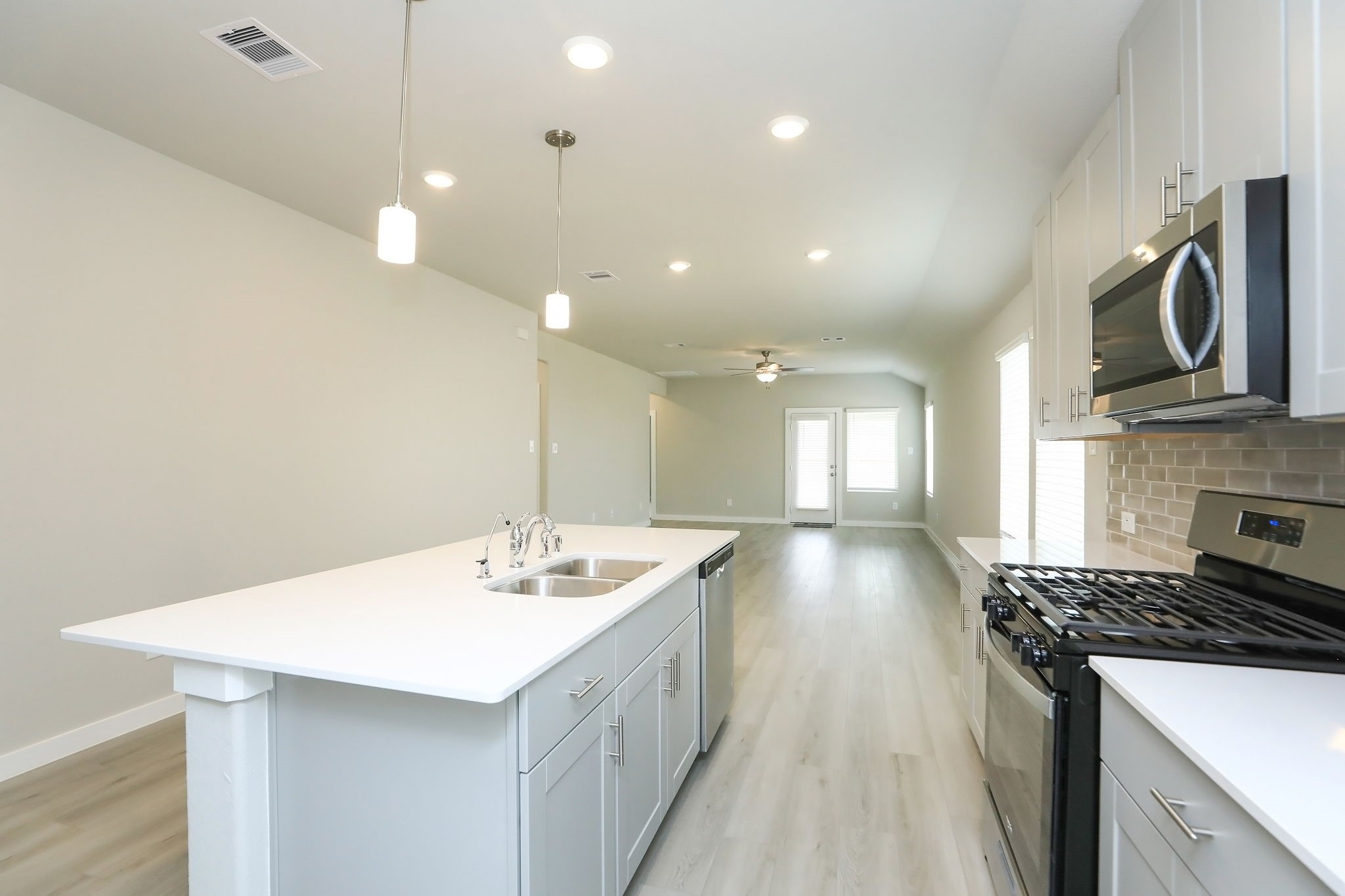 14110 Greystone Ter Street Magnolia, TX 77354 - Photo 4 of 34 The Kitchen Features A Breakfast Island With Pendant Lighting, Quartz Countertops, Stainless Steel Appliances, Shaker Cabinetry With Modern Pulls, And A Handsome Subway Tile Back Splash!