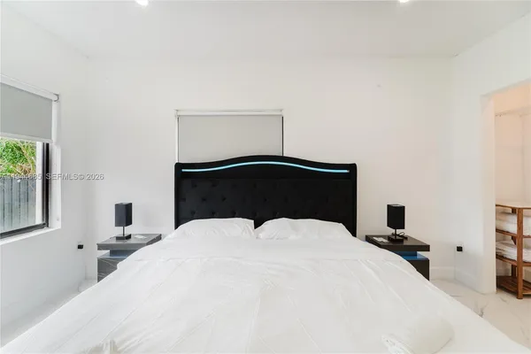 a bedroom with a bed and a painting on the wall