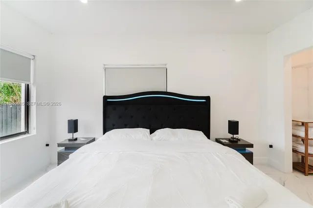 a bedroom with a bed and a painting on the wall