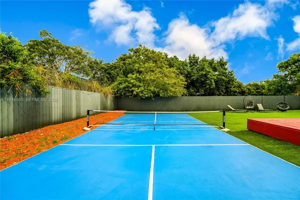 a view of a backyard with swimming pool and seating area