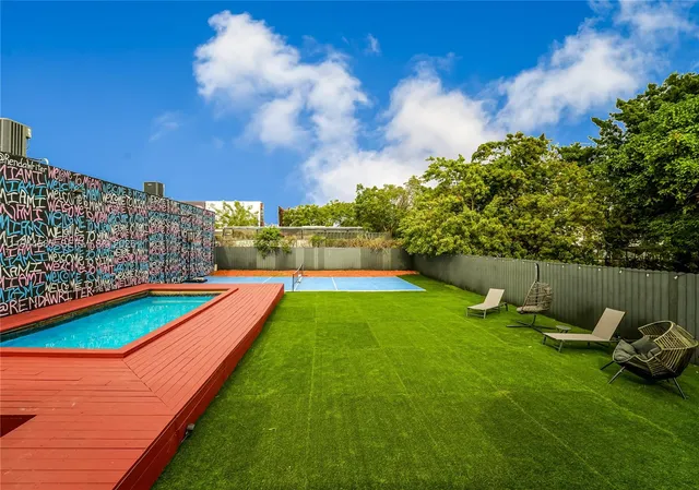 a view of a backyard with swimming pool and furniture
