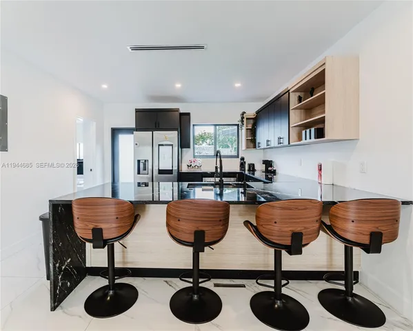 a kitchen with stainless steel appliances a sink stove and refrigerator