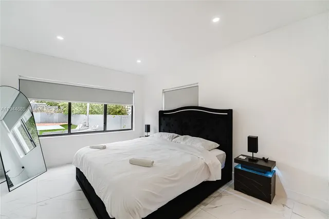 a spacious bedroom with a bed and a large window