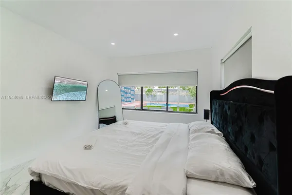 a bedroom with a bed and a large mirror