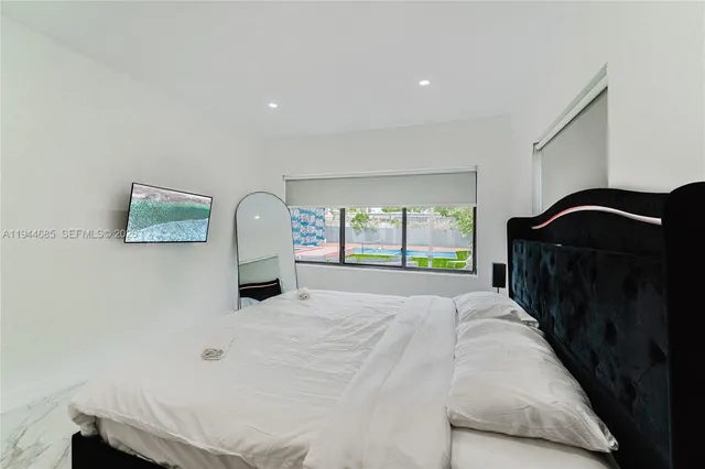 a bedroom with a bed and a large mirror