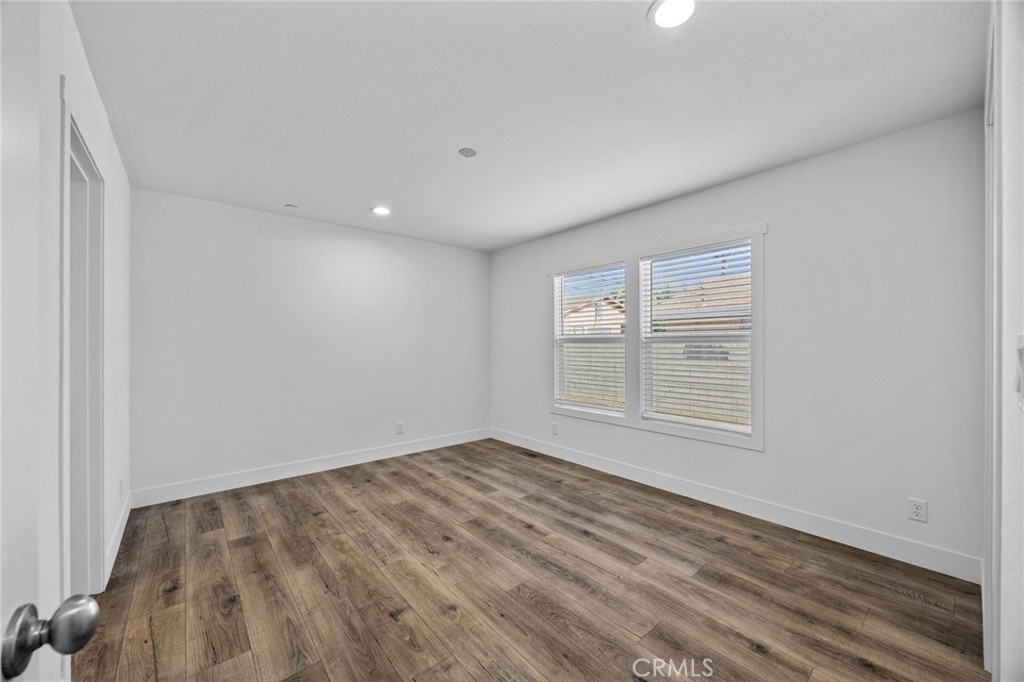 14558 Mission Street Cabazon, CA 92230 - Photo 17 of 28 an empty room with wooden floor and windows