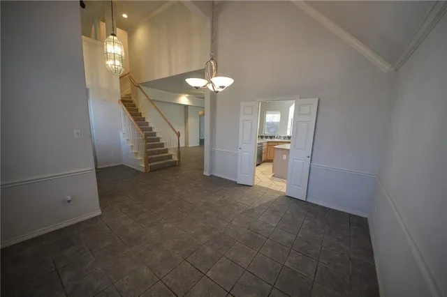 en empty room with white walls and chandelier