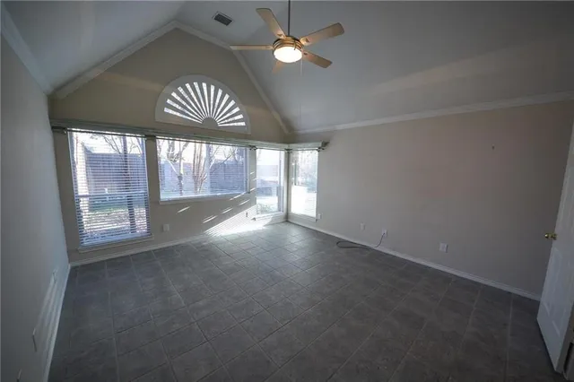 an empty room with a window and chandelier