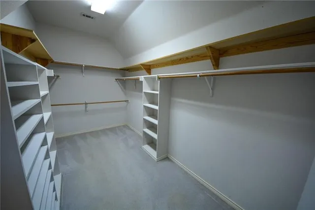a view of walk in closet with empty racks