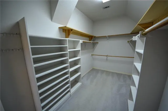 a view of walk in closet with empty racks