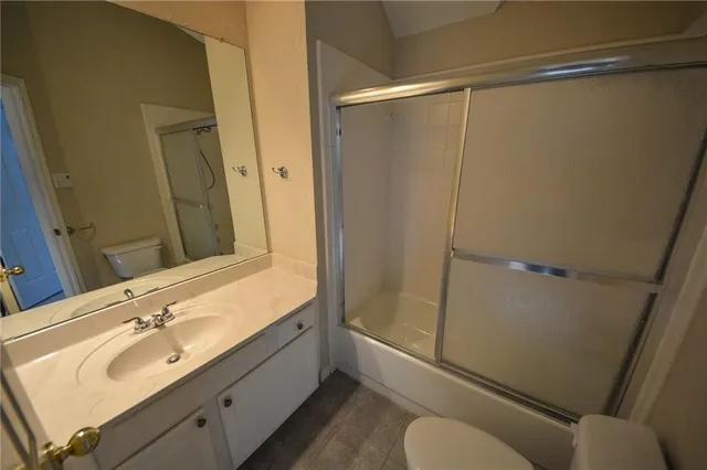 a bathroom with a sink mirror vanity and toilet