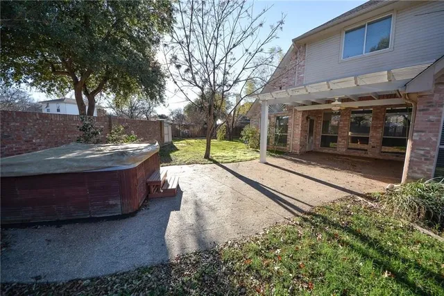 a front view of a house with a yard and large tree