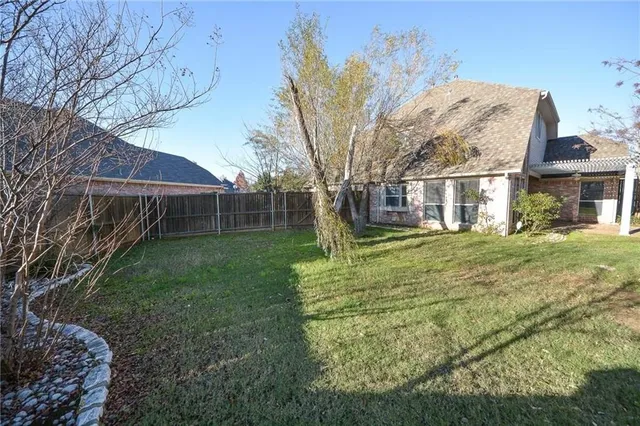 a view of a house with backyard and a tree