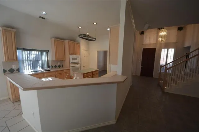 a kitchen with stainless steel appliances granite countertop a sink and a refrigerator