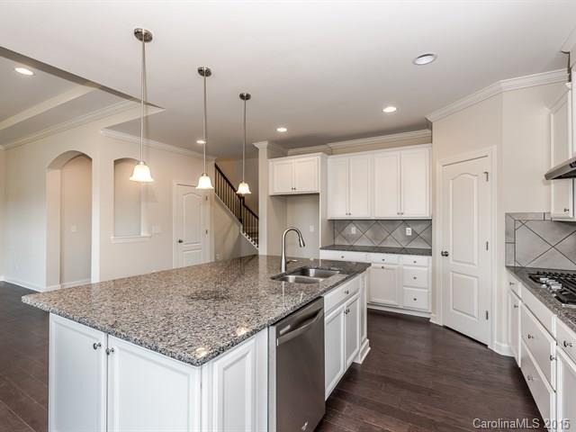 1404 Cilantro Court, Unit 309 Tega Cay, SC 29708 - Photo 8 of 24 a kitchen with stainless steel appliances granite countertop a sink a stove and a wooden floors